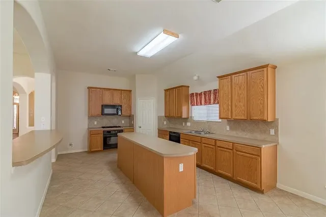 a kitchen with a sink stove and cabinets