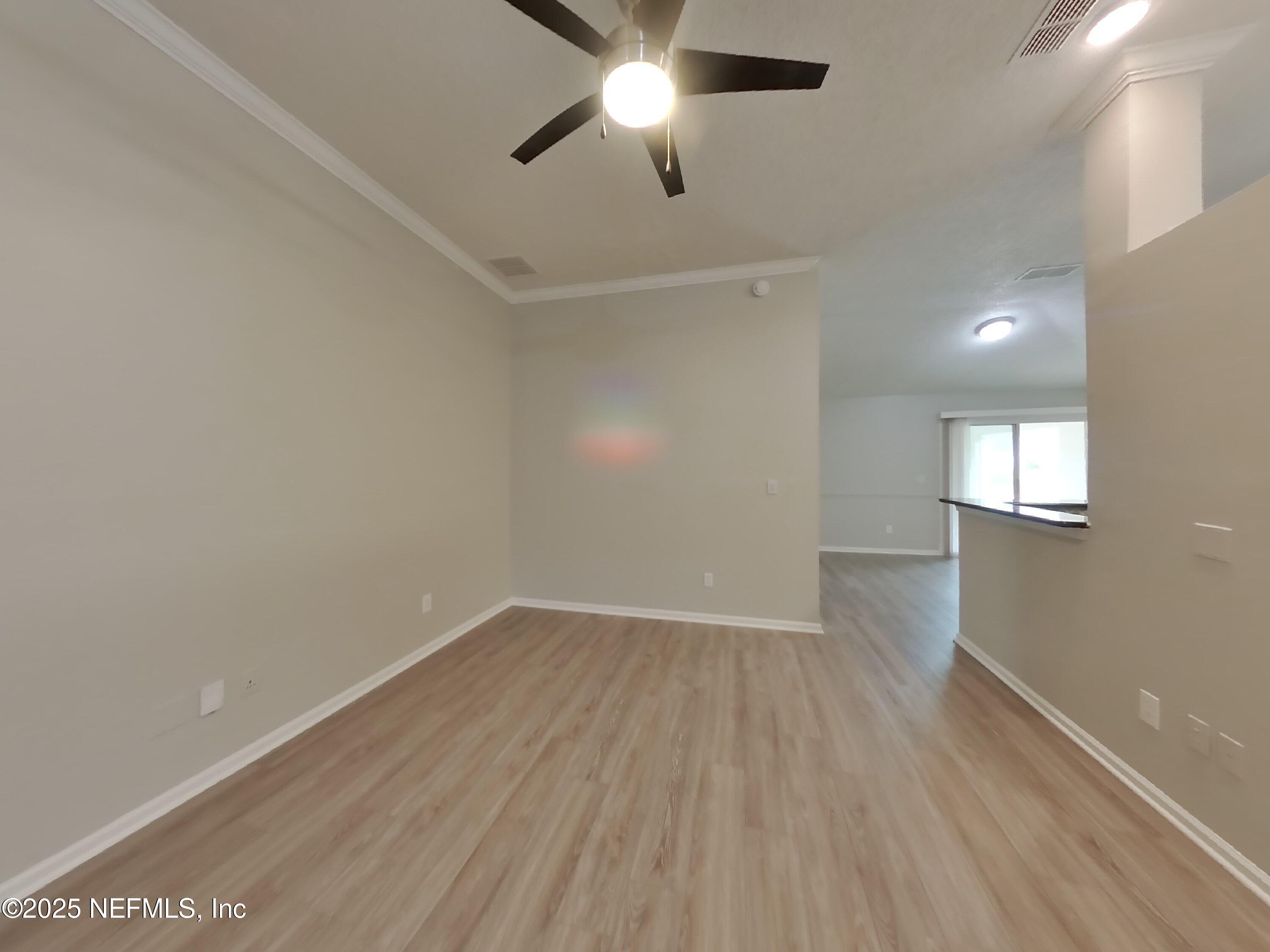 1695 Northglen Circle Middleburg, FL 32068 - Photo 2 of 14 an empty room with wooden floor ceiling fan and windows