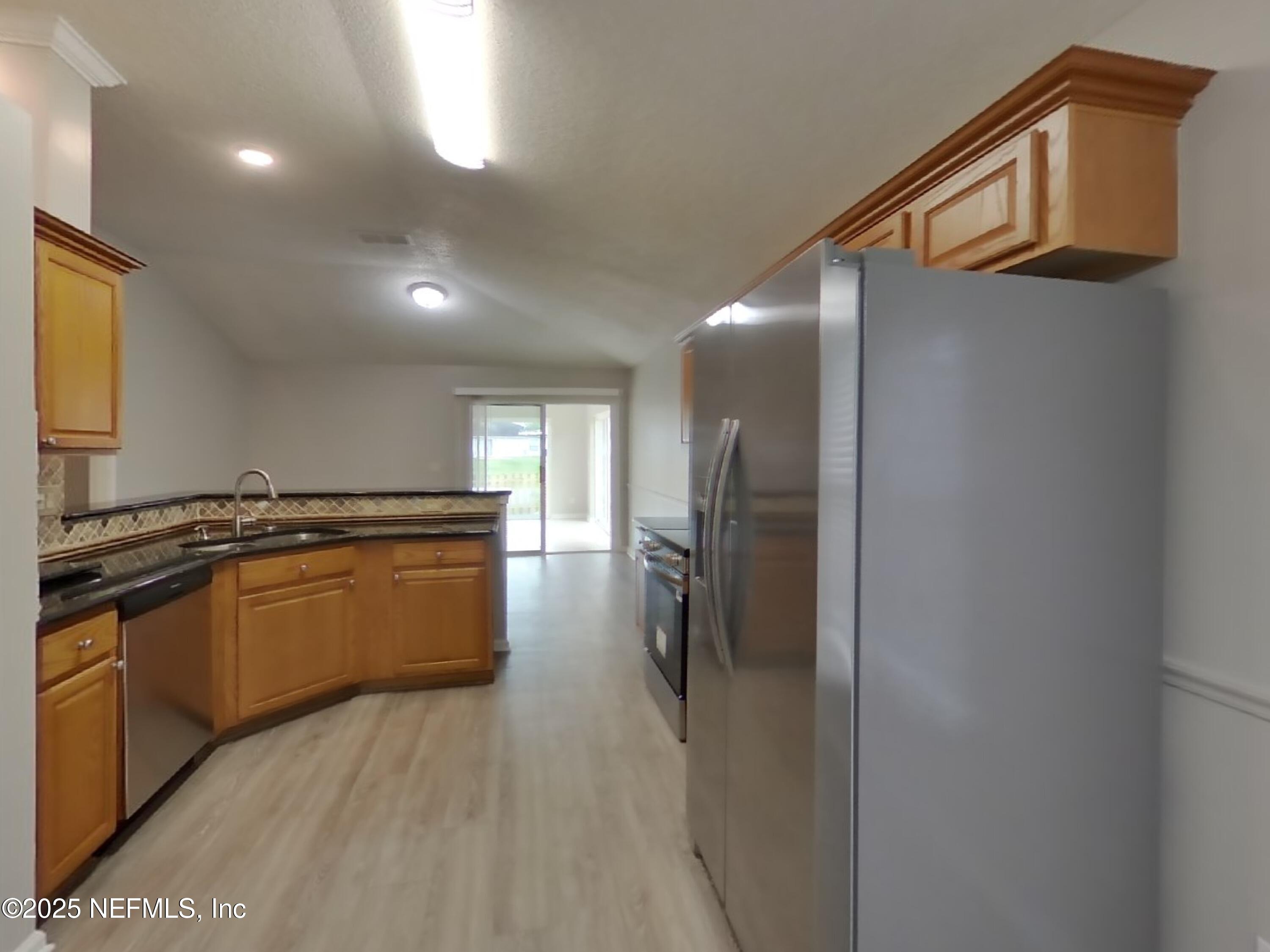 1695 Northglen Circle Middleburg, FL 32068 - Photo 4 of 14 a kitchen with stainless steel appliances granite countertop a refrigerator a sink and a stove