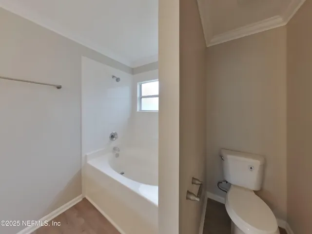 a white toilet sitting next to a bathtub