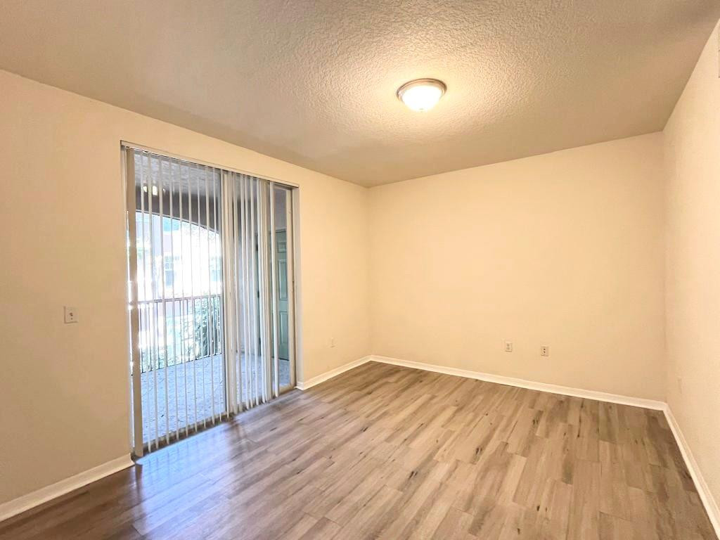 6812 West Sample Road, Unit 6812 Coral Springs, FL 33067 - Photo 14 of 27 an empty room with wooden floor and windows