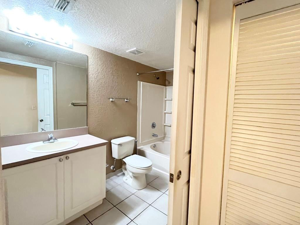 6812 West Sample Road, Unit 6812 Coral Springs, FL 33067 - Photo 16 of 27 a bathroom with a granite countertop sink a toilet and a mirror