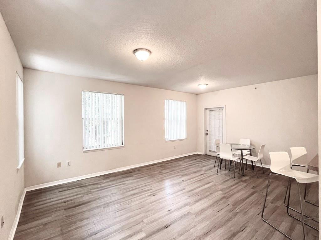 6812 West Sample Road, Unit 6812 Coral Springs, FL 33067 - Photo 6 of 27 an empty room with wooden floor and windows