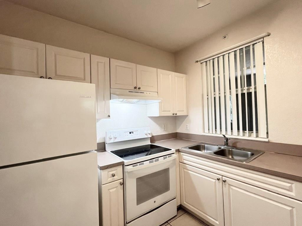 6812 West Sample Road, Unit 6812 Coral Springs, FL 33067 - Photo 10 of 27 a kitchen with a refrigerator sink stove and cabinets