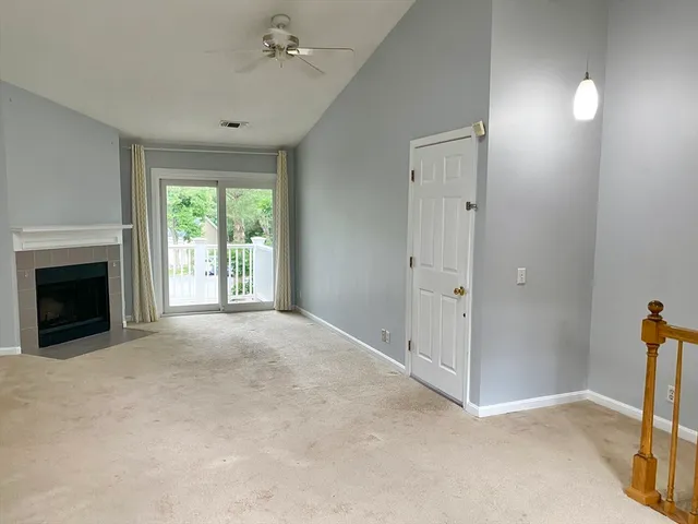 an empty room with windows and fireplace