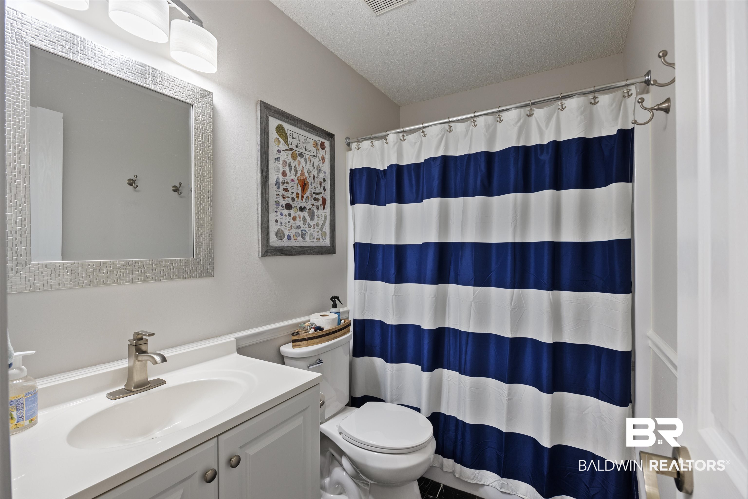 9771 Clarke Ridge Road Foley, AL 36535 - Photo 44 of 72 Bathroom featuring toilet, vanity, a textured ceiling, and a shower with shower curtain.