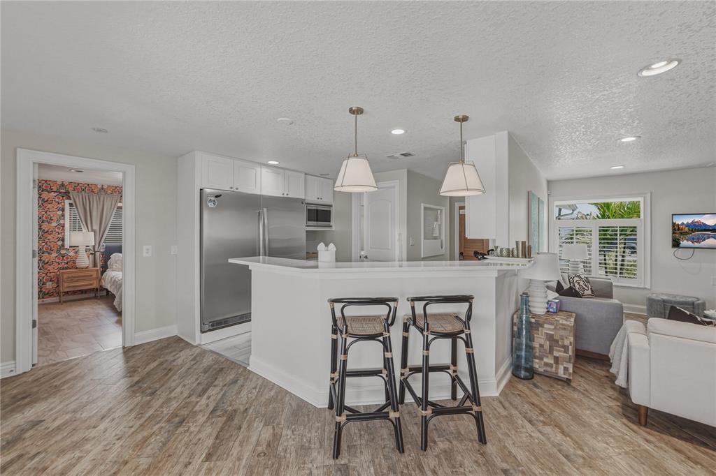 1004 Sago Palm Way Apollo Beach, FL 33572 - Photo 12 of 92 a kitchen with stainless steel appliances a dining table chairs and wooden floor