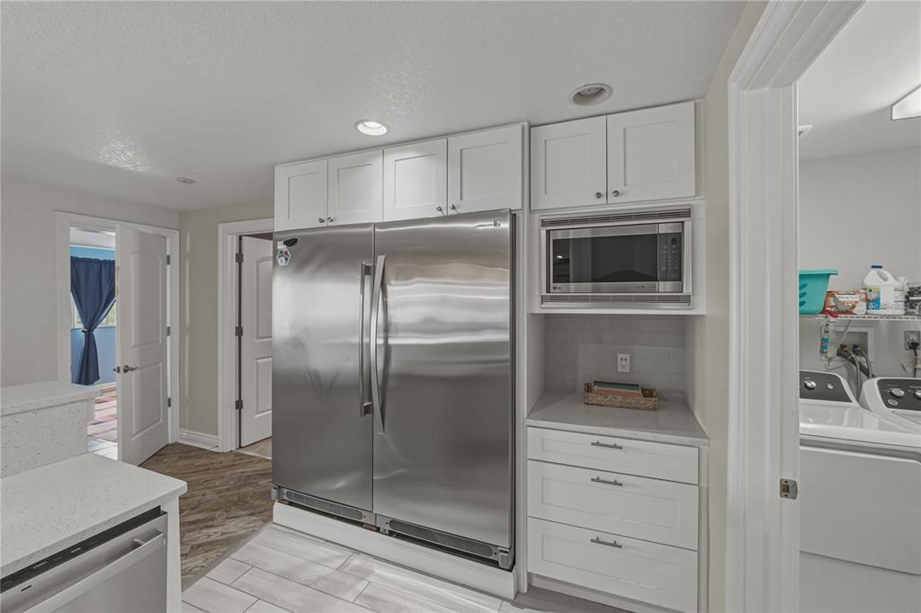 1004 Sago Palm Way Apollo Beach, FL 33572 - Photo 18 of 92 a kitchen with kitchen island a counter top space cabinets and stainless steel appliances