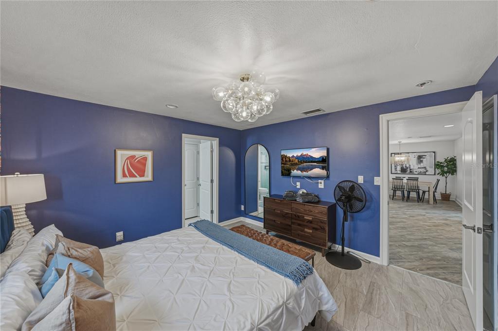 1004 Sago Palm Way Apollo Beach, FL 33572 - Photo 23 of 92 a bedroom with a bed and a chandelier