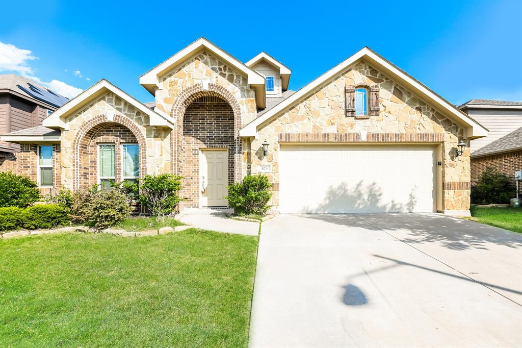 a front view of a house with a yard and garage