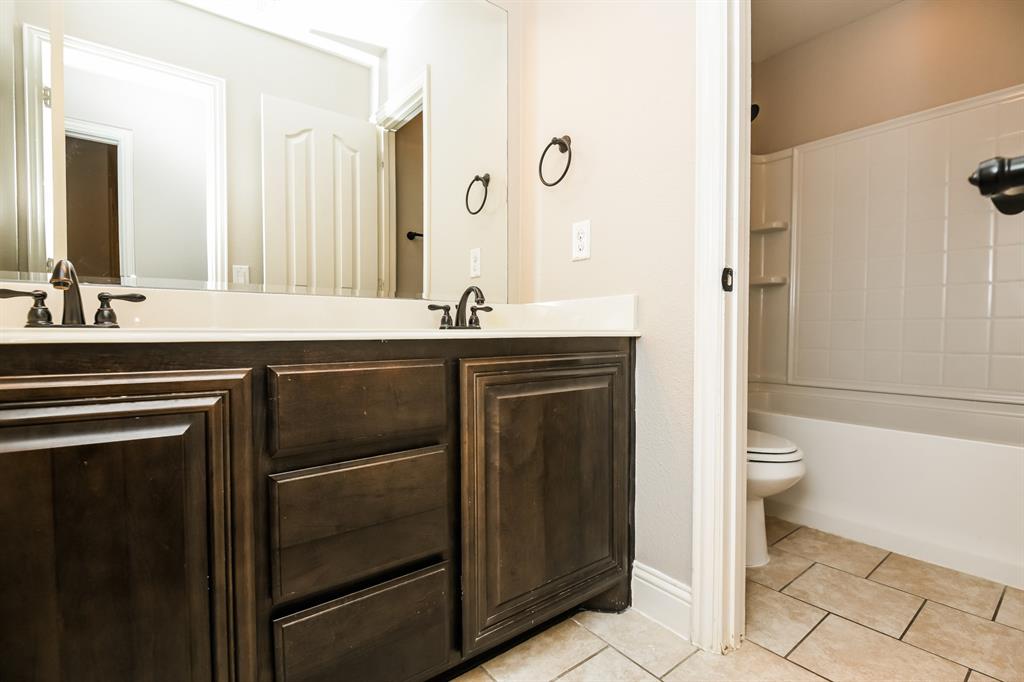 826 Graham Drive Burleson, TX 76028 - Photo 16 of 18 a bathroom with a granite countertop sink toilet and shower