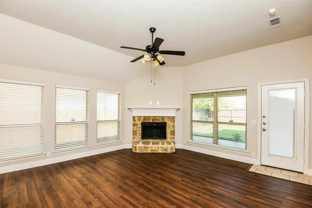 826 Graham Drive Burleson, TX 76028 - Photo 2 of 18 a view of an empty room with wooden floor fireplace and a window