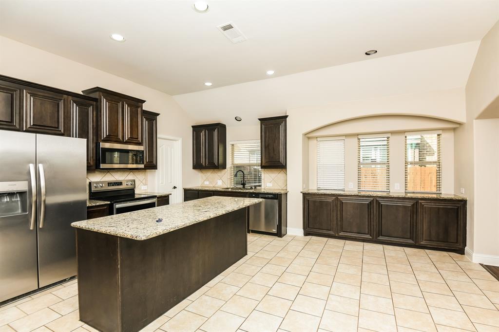 826 Graham Drive Burleson, TX 76028 - Photo 6 of 18 a large kitchen with stainless steel appliances granite countertop a sink counter space cabinets and a large window