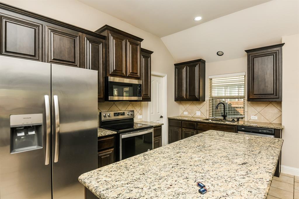 826 Graham Drive Burleson, TX 76028 - Photo 7 of 18 a kitchen with stainless steel appliances kitchen island granite countertop a refrigerator stove and sink