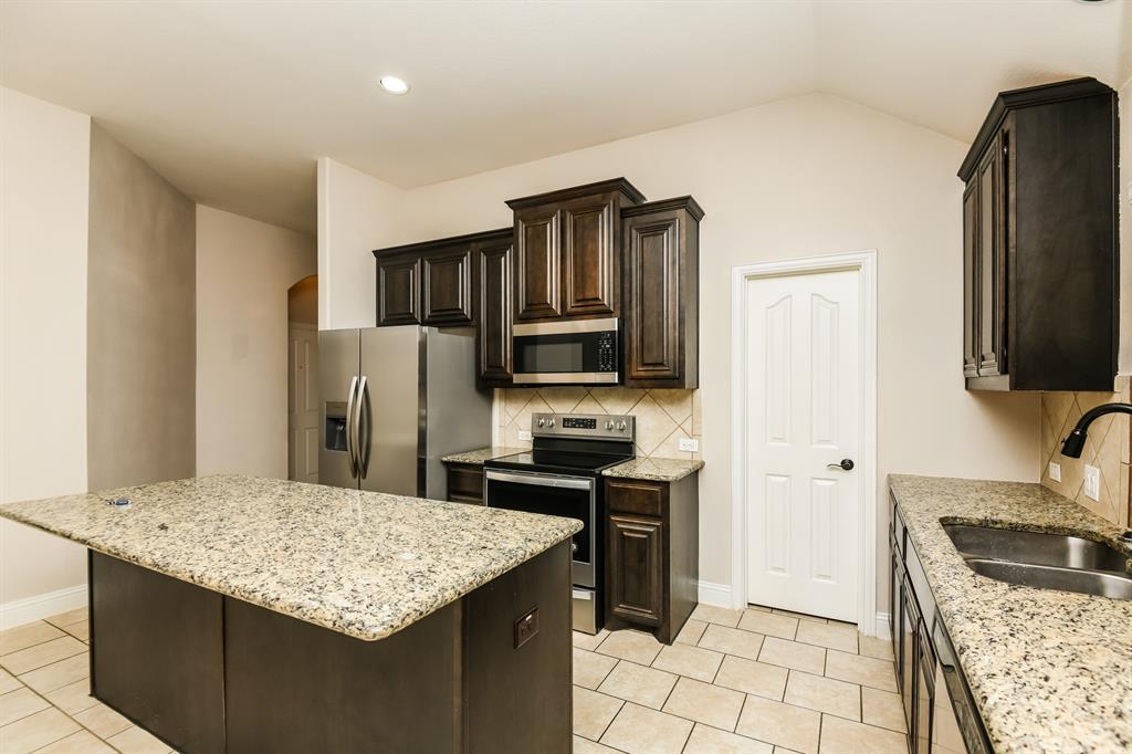 826 Graham Drive Burleson, TX 76028 - Photo 8 of 18 a kitchen with stainless steel appliances granite countertop a sink stove and refrigerator