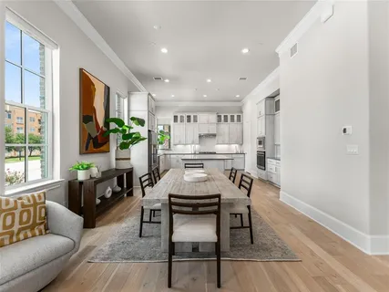 a bedroom with a bed couches chair and three large window