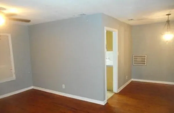 a view of an empty room with closet and a window