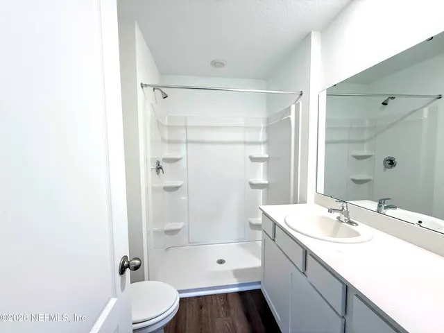 a bathroom with a sink a toilet and shower