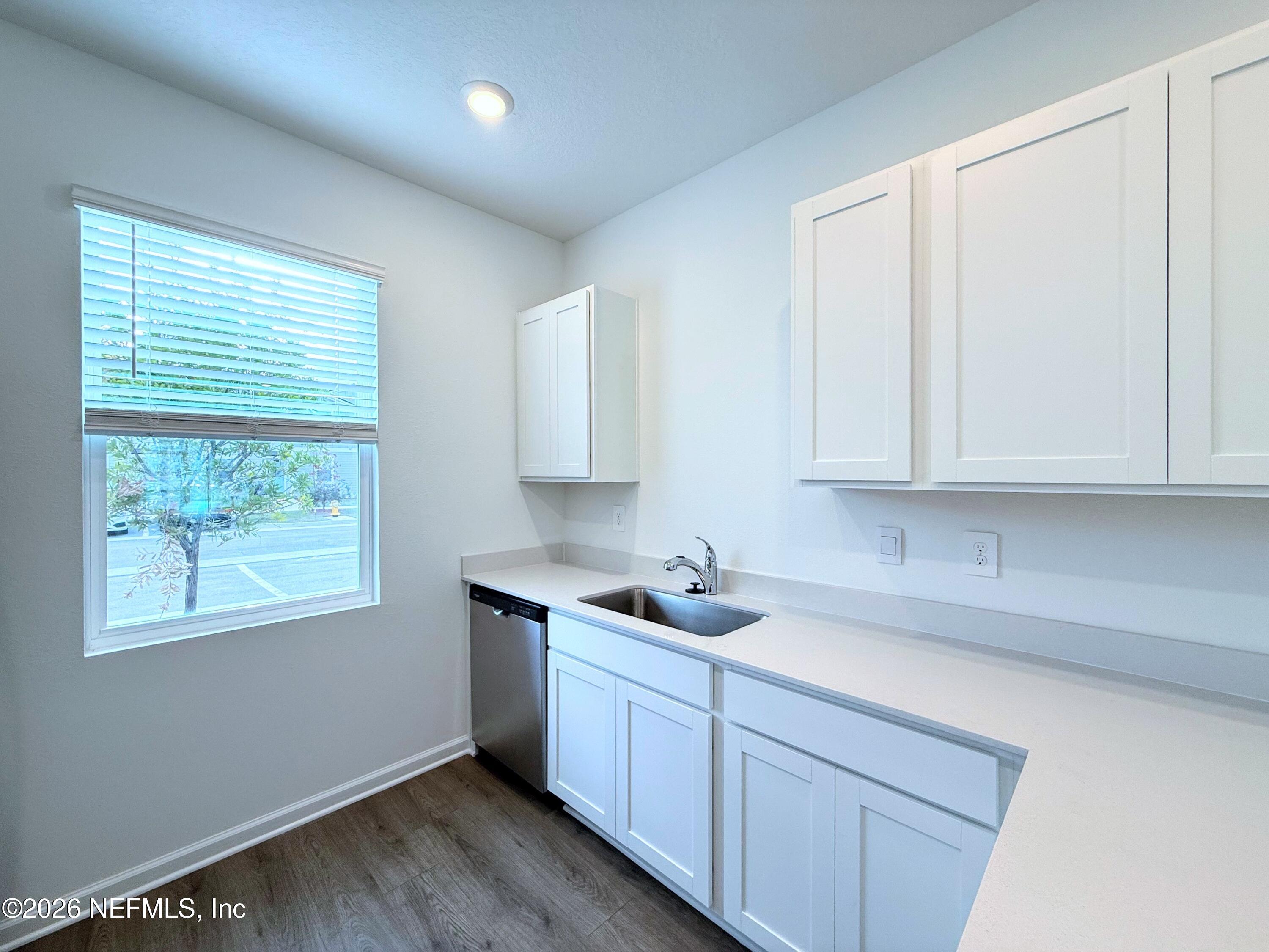 131 Palmetto Rdg Road St. Augustine, FL 32095 - Photo 5 of 20 a kitchen with stainless steel appliances granite countertop white cabinets sink and window