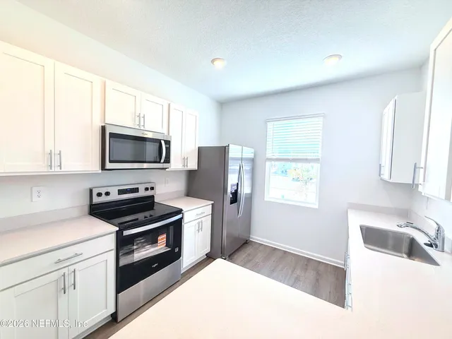 a kitchen with a sink a stove and cabinets