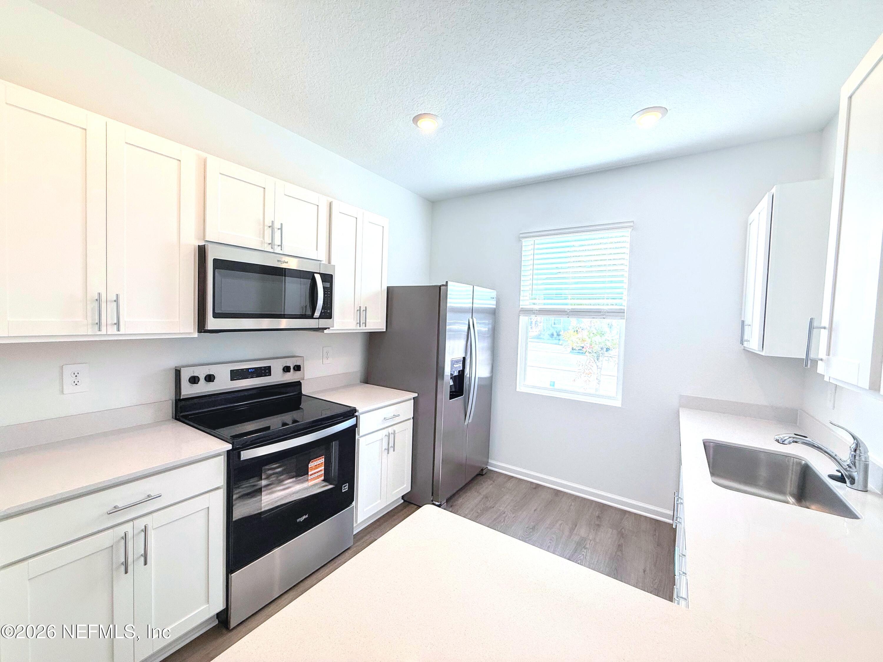 131 Palmetto Rdg Road St. Augustine, FL 32095 - Photo 6 of 22 a kitchen with a sink a stove and cabinets