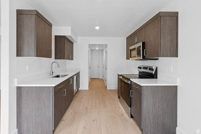 1617 North Angel Street Layton, UT 84041 - Photo 22 of 43 Kitchen featuring stainless steel appliances, dark brown cabinets, modern cabinets, and light wood-type flooring