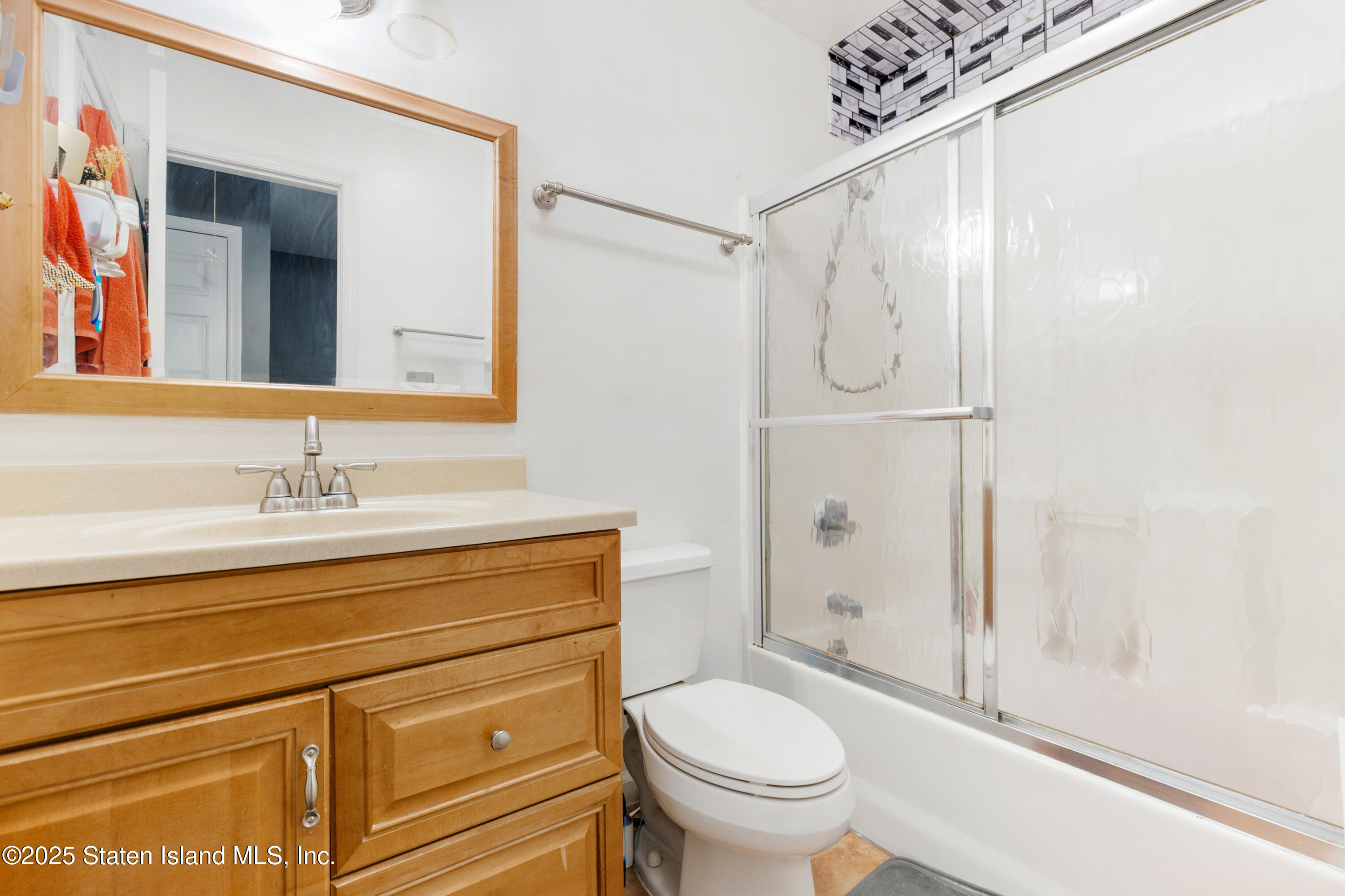 263 Jamie Lane Staten Island, NY 10312 - Photo 37 of 44 a bathroom with a granite countertop sink a toilet and shower