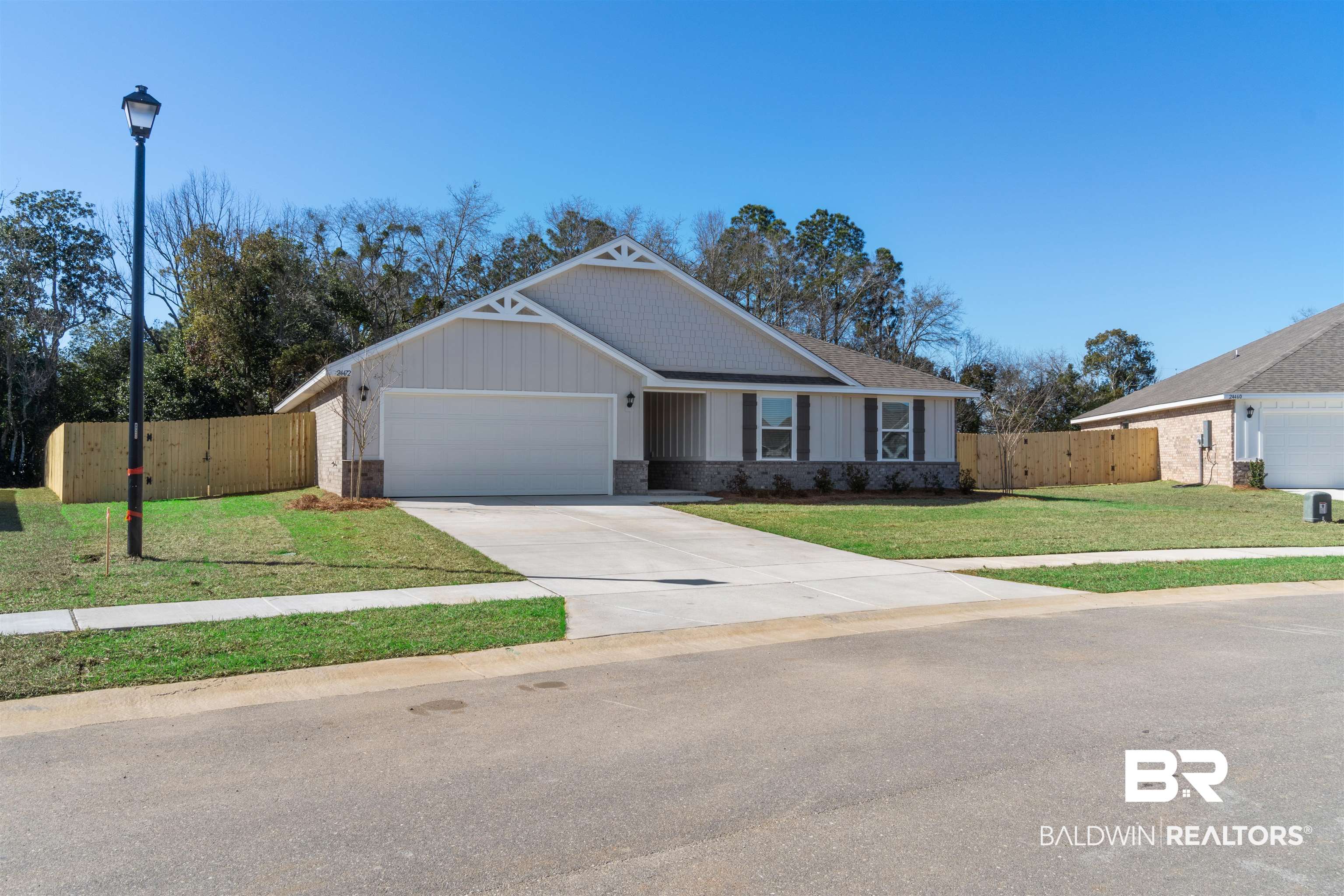 24472 Ringneck Loop Elberta, AL 36530 - Photo 2 of 46 View of front of house featuring a front yard, an attached garage, fence, and driveway