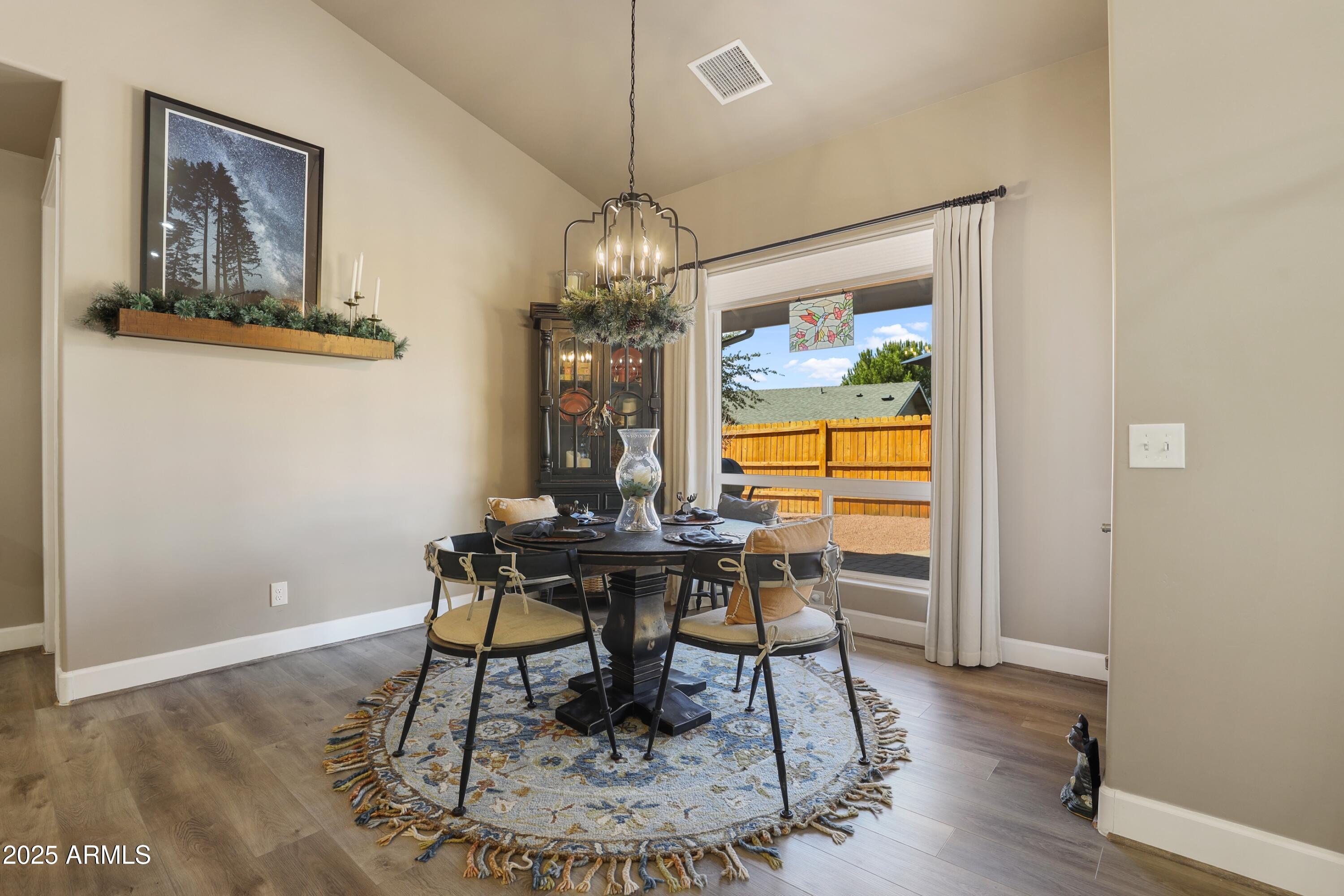 506 North Eagle Ridge Road Payson, AZ 85541 - Photo 13 of 41 a dining room with wooden floor a chandelier a wooden table and chairs