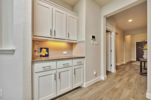 a kitchen with white cabinets and refrigerator