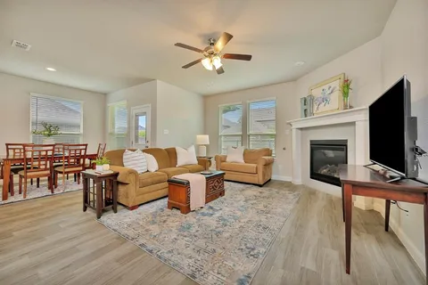 a living room with furniture a flat screen tv and a fireplace