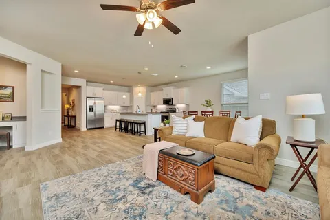 a living room with furniture and kitchen view