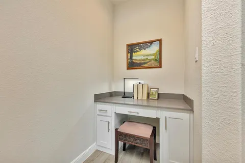 a view of a workspace with furniture and wooden floor