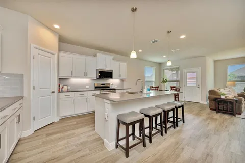 a kitchen with appliances a sink a counter top space and cabinets