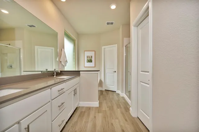 a spacious bathroom with a double vanity sink and a mirror