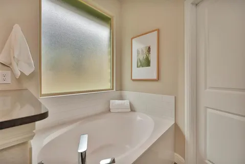 a bathroom with a white tub and a window