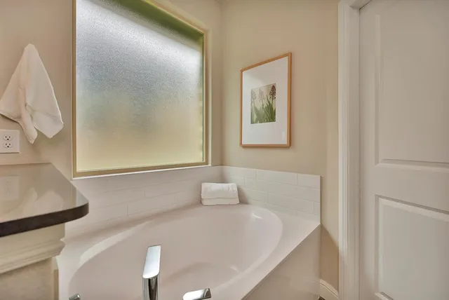a bathroom with a white tub and a window