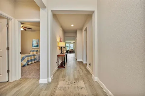 a view of a hallway with wooden floor and a living room
