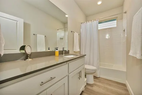 a bathroom with a double vanity sink toilet and a shower