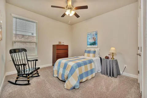 a bedroom with a bed chair and window