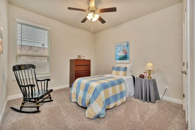 a bedroom with a bed chair and window