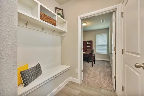 a view of a hallway with wooden floor and a living room