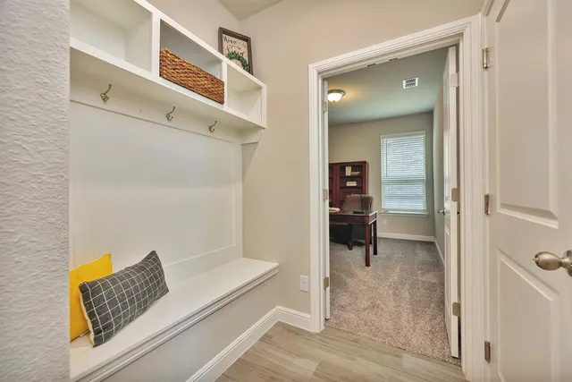 a view of a hallway with wooden floor and a living room