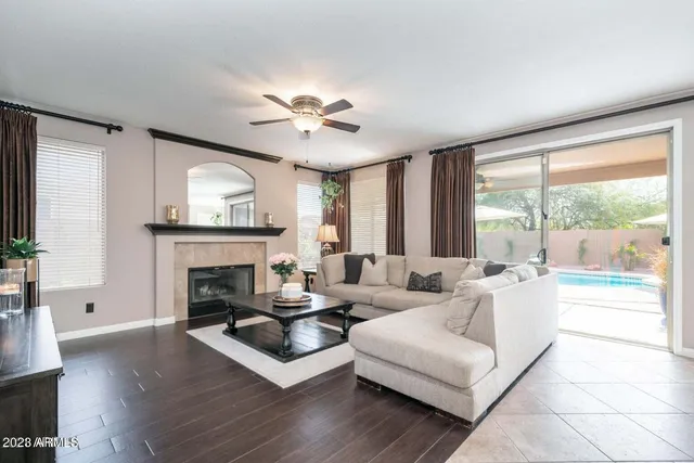 a living room with furniture a fireplace and a large window