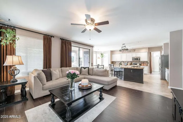 a living room with furniture kitchen view and a large window