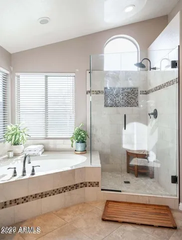 a bathroom with a tub a double vanity sink and a large mirror