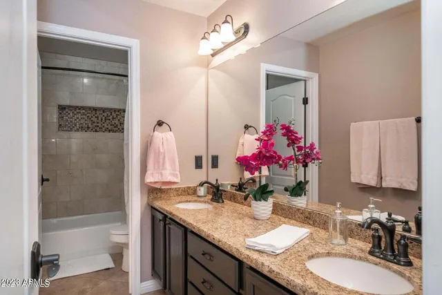 a bathroom with a granite countertop sink a large mirror and a bathtub