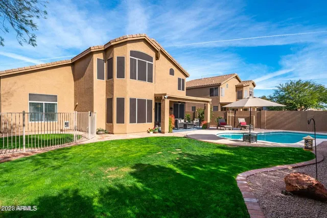 a front view of a house with swimming pool having outdoor seating