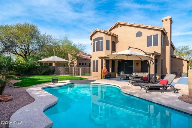 a front view of a house with swimming pool having outdoor seating
