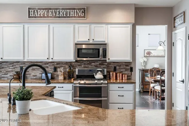 a kitchen with stainless steel appliances kitchen island granite countertop a stove a sink and a microwave